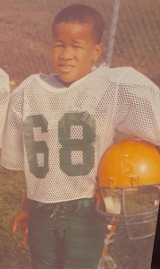 Lamar as a child in his football uniform