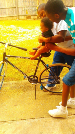 Tyrin Terrell Colbert pushing his sibling on a bike